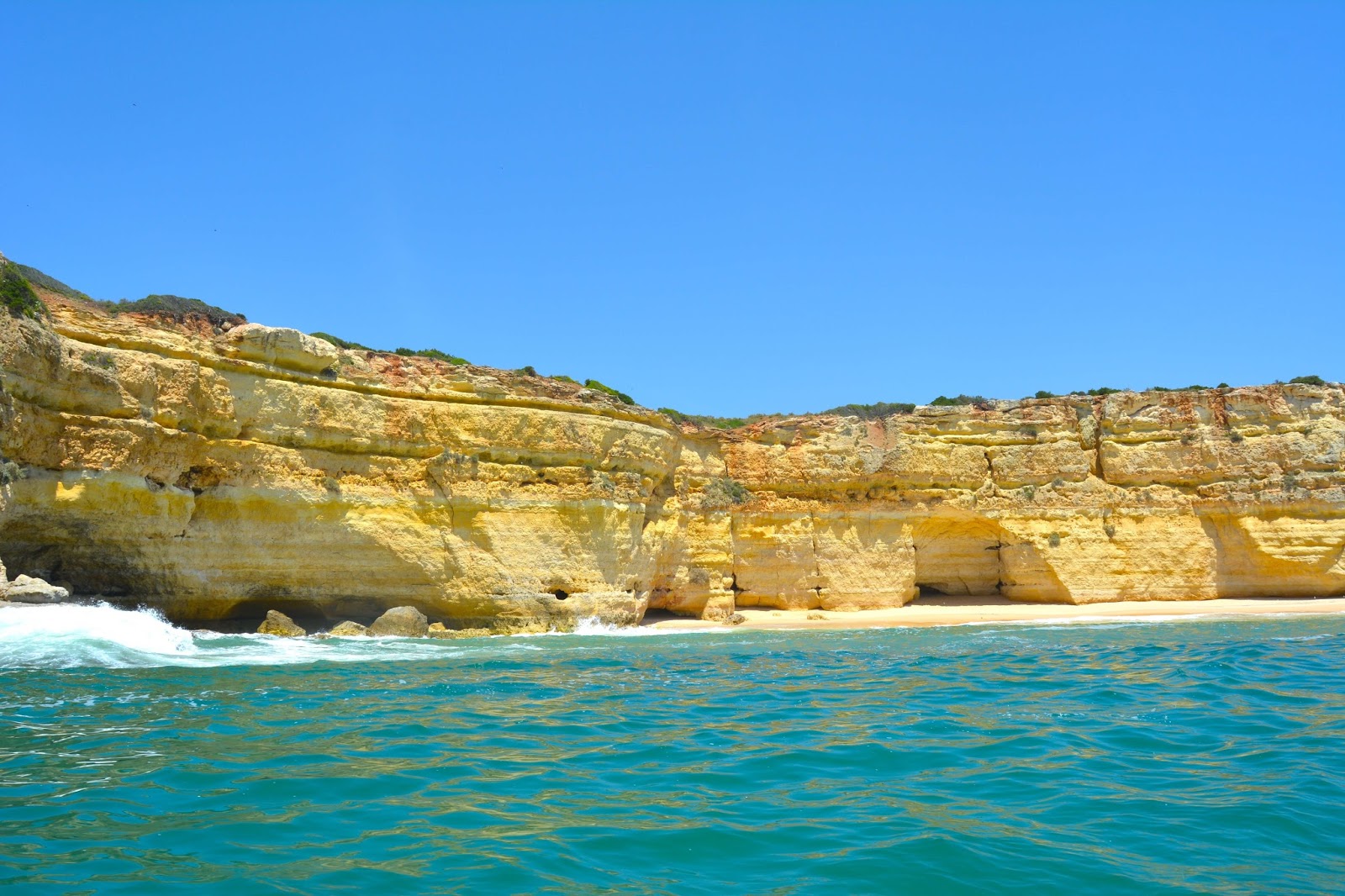 In this photo, you will see golden cliffs and turquoise waters. It was taken in the region of Algarve in Portugal known for its gorgeous coastline.