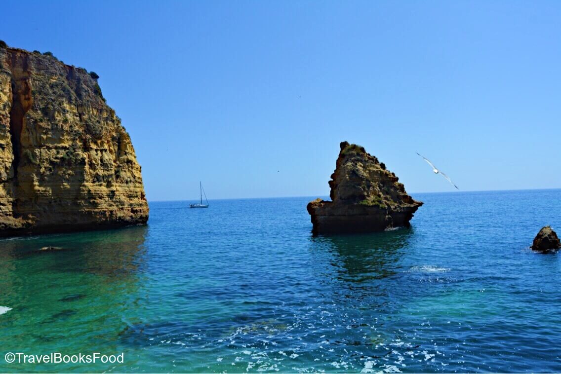 A golden cliff surrounded by turquoise waters in Algarve, Portugal