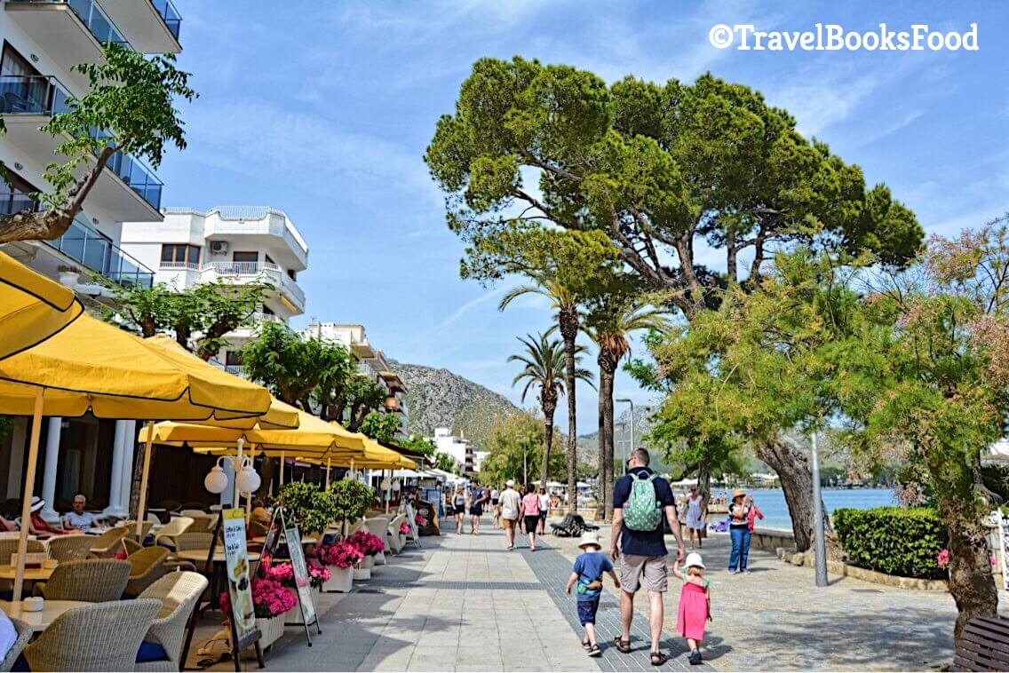 This is a photo of a pathway in Port De Pollenca in Mallorca. It is the beach on one side and hotels on the other side.