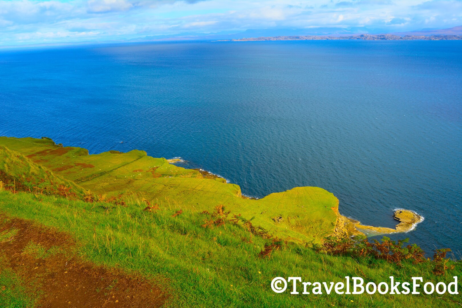 A view of a gorgeous blue coloured ocean from bright green cliffs in Isle Of Skye, Scotland