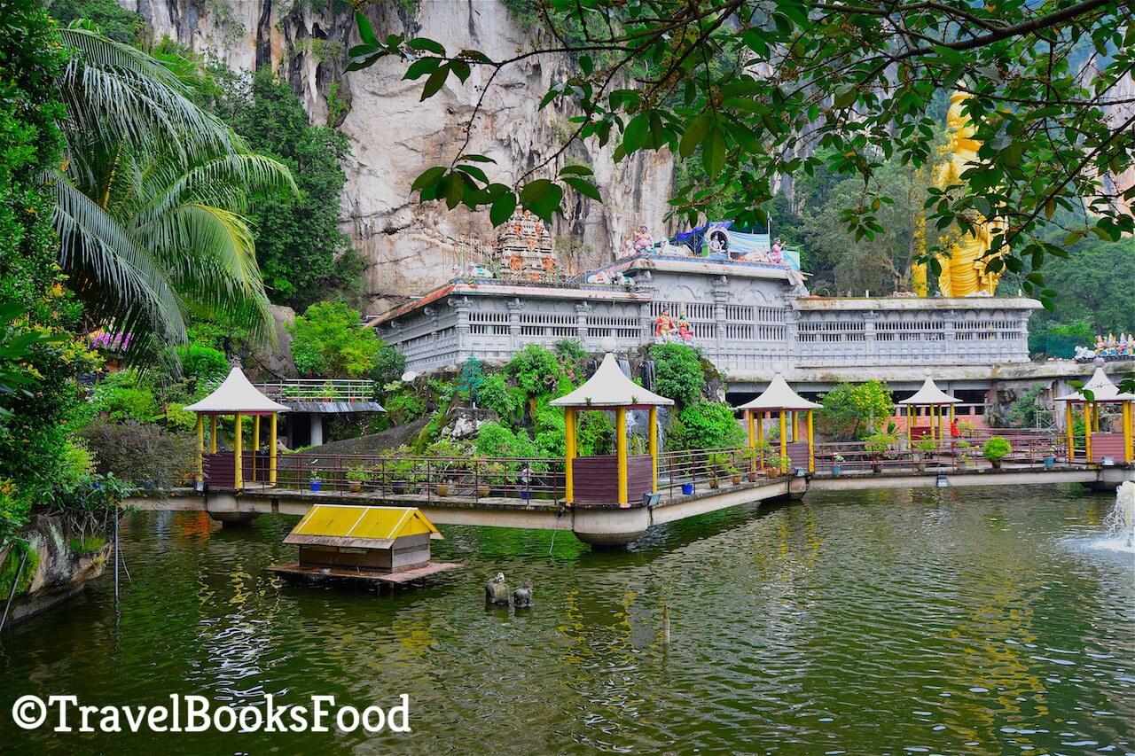 A photo of the entrance of the Batu Caves from another angle. You can see the statue in the distance with a lake in the front of it