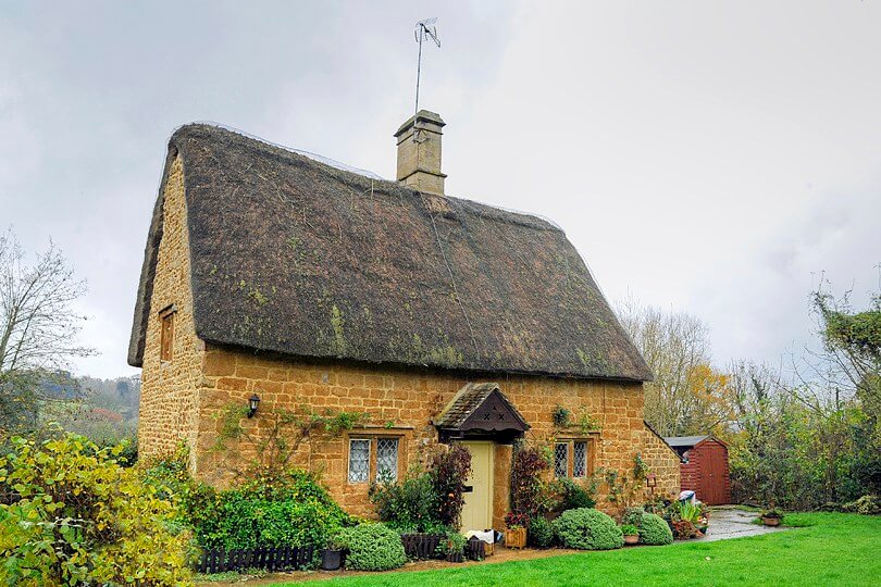 A photo of a thatched cottage in Cotswold with a pretty garden