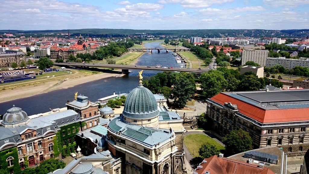 A photo of a city with a building with blue dome taken from a bird viewpoint