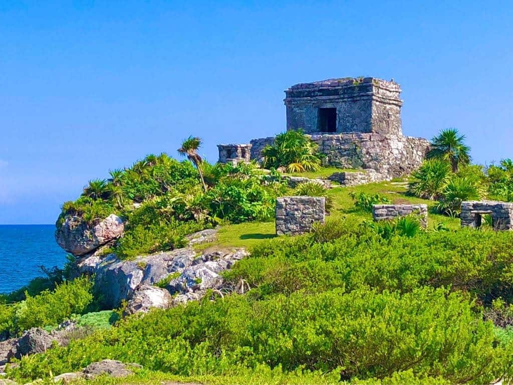 Tulum - Best places to visit in Mexico. A ruin on top of a hill in Tulum overlooking the sea on a sunny day